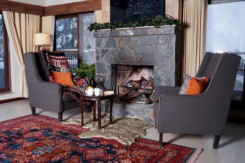 a living room with two chairs and a fireplace at Cedar Lodges Resort and Residences Galiyat in Chhāngla Gali