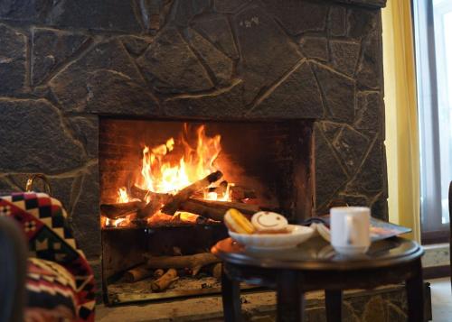 a fire in a fireplace with a bowl of food on a table at Cedar Lodges Resort and Residences Galiyat in Chhāngla Gali