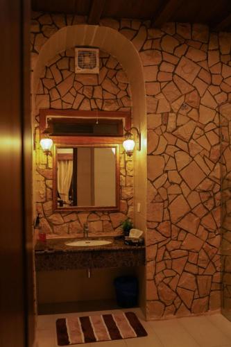 a bathroom with a sink and a stone wall at Cedar Lodges Resort and Residences Galiyat in Chhāngla Gali