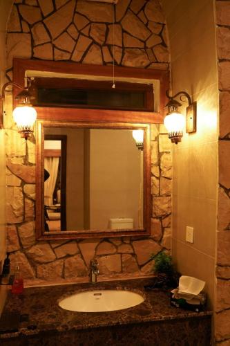 a bathroom with a sink and a mirror at Cedar Lodges Resort and Residences Galiyat in Chhāngla Gali