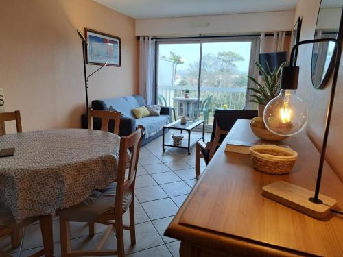 un salon avec une table et une salle à manger dans l'établissement Appartement cosy près de la plage avec balcon, Wi-Fi et parking – Saint-Jean-de-Monts - FR-1-323-508, à Saint-Jean-de-Monts