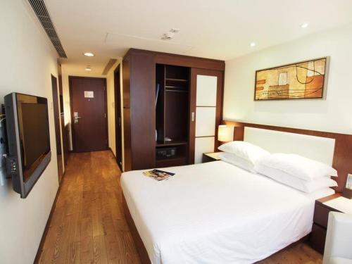 a bedroom with a white bed and a flat screen tv at 218 Apartment in Hong Kong