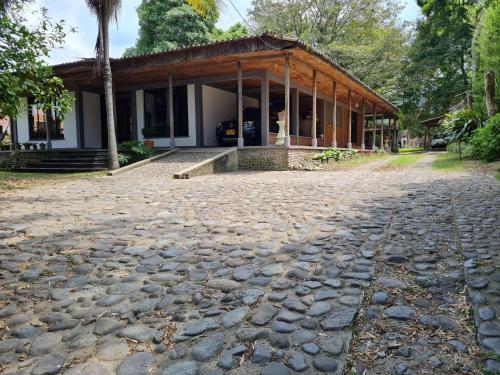 een huis met een geplaveide straat ervoor bij Casa Vélez: habitación natural in Villamaría