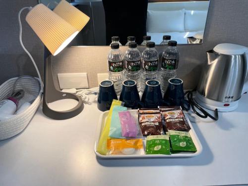 a tray of food and bottles of water on a desk at 藝築文旅-昆明館Artinn Kunming in Taipei