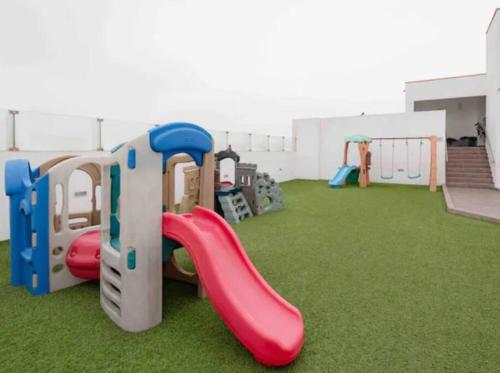 a play room with a playground with a slide at Departamento con vista al mar in Lima