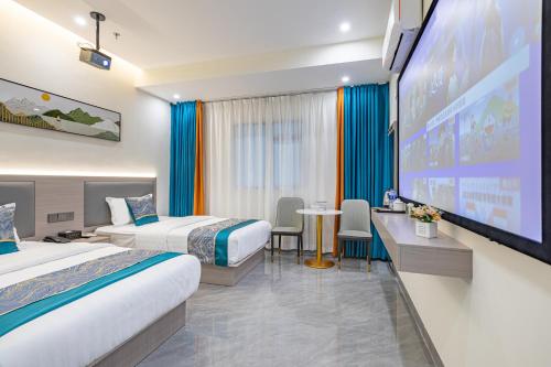 a hotel room with two beds and a projection screen at Zhuhai Golden Lake Bay Hotel in Zhuhai