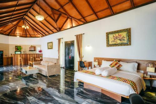 de Bintan Villa في Tenaga: غرفة نوم مع سرير وغرفة معيشة