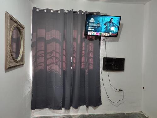 Cette chambre comprend un rideau et une télévision murale. dans l'établissement Mi casa, à Ciudad Juárez