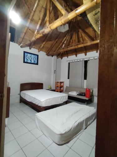 um quarto com 2 camas e um tecto de madeira em Casa BBb Punta Hermosa Planicie em Punta Hermosa