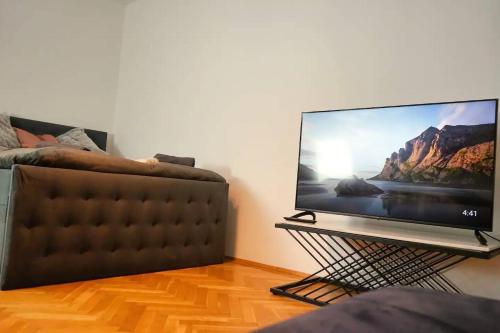 a flat screen tv sitting on a stand next to a couch at City Nook Apartments Near Hauptbahnhof in Vienna