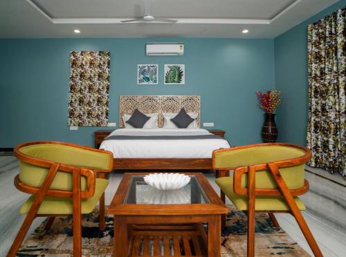 1 Schlafzimmer mit einem Bett und 2 Stühlen in der Unterkunft MERAKI VILLA - 5 BR Luxury Villa with private pool in Udaipur