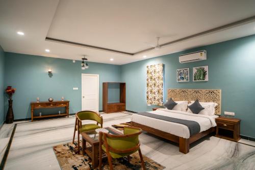 Schlafzimmer mit blauen Wänden, einem Bett und einem Schreibtisch in der Unterkunft MERAKI VILLA - 5 BR Luxury Villa with private pool in Udaipur