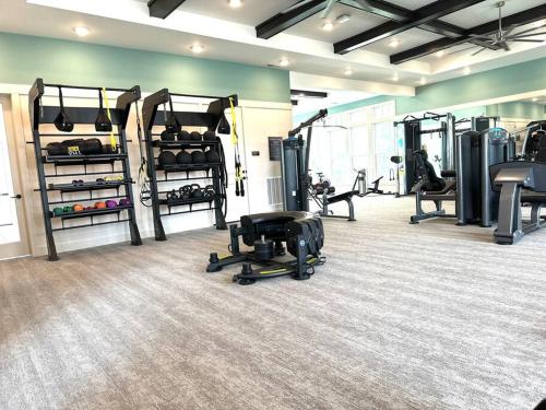 einen Fitnessraum mit Laufbändern und Maschinen in einem Zimmer in der Unterkunft Boho Chic Luxury Retreat 5 Min to Parks & Food in Orlando