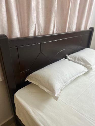 a bed with a black headboard and two pillows at Luxurious Homely Private Room In Posh Locality One in Chennai