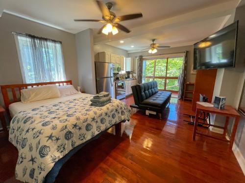 um quarto com uma cama e uma cadeira em Villas De Cisnes Starfish or Anchor floors em Roatan