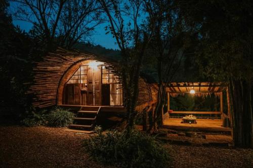 a small log cabin at night with a bench in front at The River whisper in Ban Ton Kham