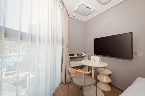 a room with a table and a tv and a bed at Sollago Myeongdong Hotel & Residence in Seoul
