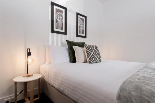 1 dormitorio con cama blanca y mesa auxiliar en Gorgeous on Gleadow: The Twin, en Invermay