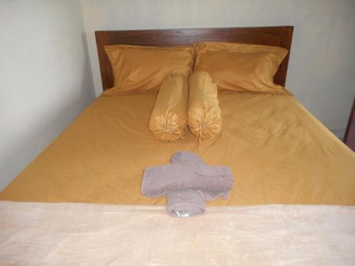 - une serviette sur un lit avec une paire de chaussures dans l'établissement Jro Pesimpangan Homestay, à Besakih