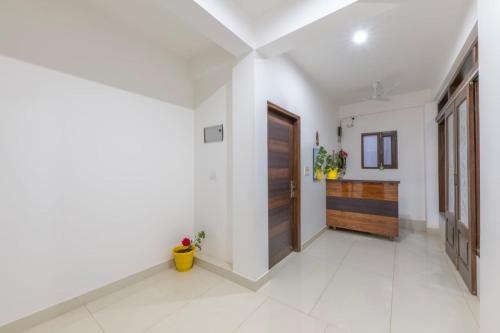 a hallway with a wooden door and a white tile floor at Wonder Inn Kasauli in Kasauli