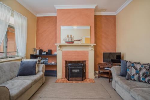 a living room with a couch and a fireplace at Albany Historic Cottage by the BnB Collection in Albany