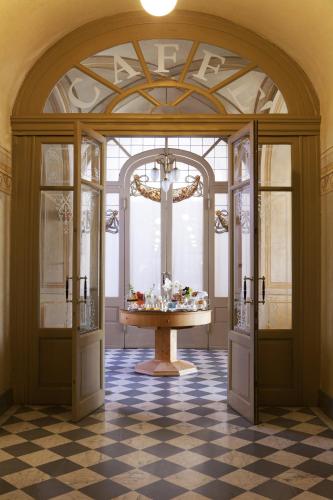 a room with an open door with a table in it at QC Grand Hotel Bagni Nuovi in Bormio