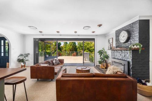 a living room with a couch and a fireplace at Kooyong, Kangaroo Valley in Kangaroo Valley