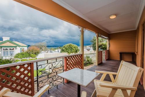 a patio with a table and chairs on a balcony at Albany Historic Cottage by the BnB Collection in Albany