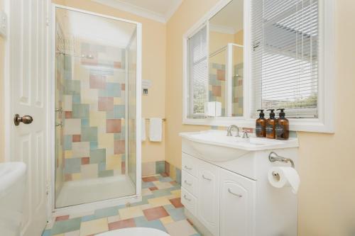 a bathroom with a toilet sink and a shower at Albany Historic Cottage by the BnB Collection in Albany