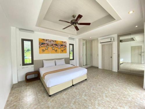 - une chambre avec un lit et un ventilateur de plafond dans l'établissement Lakeview Pool Villa Near Beautiful Beach VCS1, à Phuket