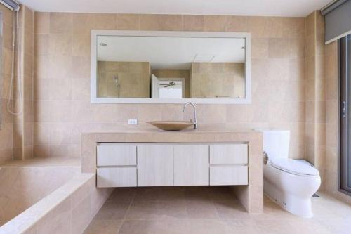 La salle de bains est pourvue d'un lavabo, de toilettes et d'un miroir. dans l'établissement Lakeview Pool Villa Near Beautiful Beach VCS1, à Phuket