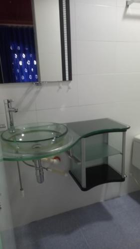 a glass sink in a bathroom with a mirror at Hotel Perla Azul Boutique in Girardot