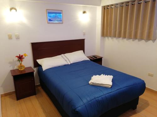 a bedroom with a bed with blue sheets and white pillows at El Ave Azul Boutique Hotel Cusco in Cusco