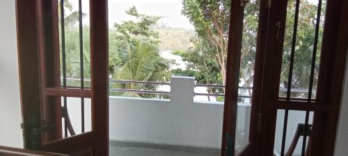 an open door with a view of a balcony at The Green Lagoon Villa in Hikkaduwa