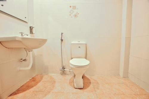 a bathroom with a white toilet and a sink at Stayz Inn Hotels - The Gate Way Of Madras - Near Chennai Central Railway Station in Chennai