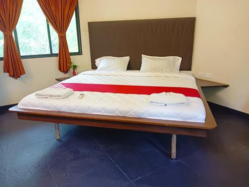 a large bed with two towels on top of it at Smiley Resorts in Auroville