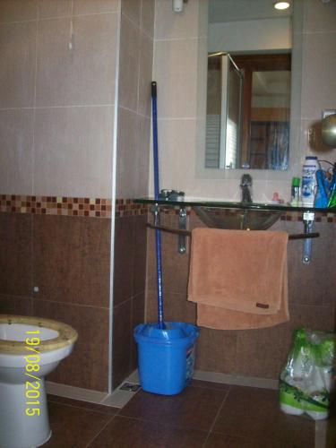 a bathroom with a toilet and a blue bucket at Jomtien Condotel Condominium in Pattaya South