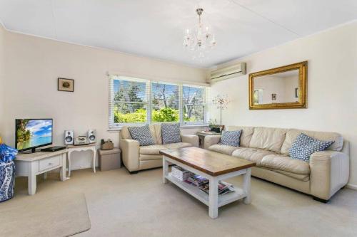 a living room with a couch and a table at Lavender Cottage Leura in Leura