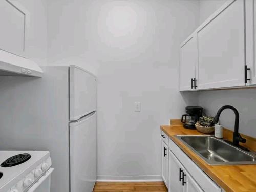 a white kitchen with a sink and a refrigerator at King's Palace in Lodwar