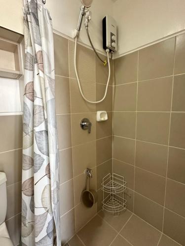 a shower with a shower curtain in a bathroom at Bright & Breezy 2 BR Unit with Balcony in Manila