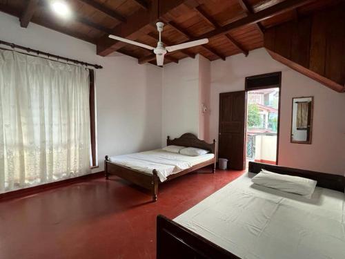 a bedroom with two beds and a ceiling fan at Bellevue Retreat in Kandy