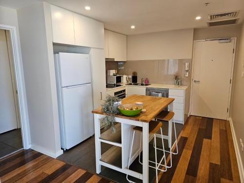 a kitchen with a wooden table and a white refrigerator at Spacious Modern Apartment in Prime Location in Wickham