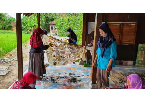 a group of people working on a mosaic floor at Yukke Tembi Homestay in Yogyakarta
