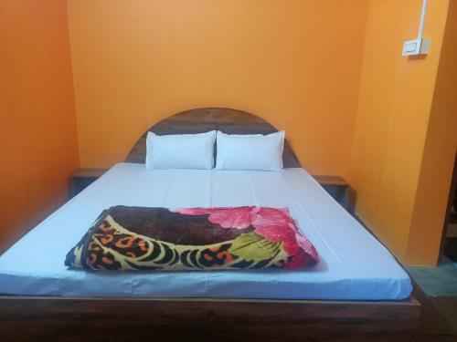 a bed with a colorful blanket on top of it at Singhik Hotel Kanchen View in Singhik
