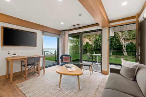 a living room with a couch and a table and a desk at SA Carbon Beach Suites in Malibu