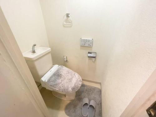 een badkamer met een toilet en slippers bij TasoneUrbanStayOsaka 心斎橋東アクエルド502 in Osaka