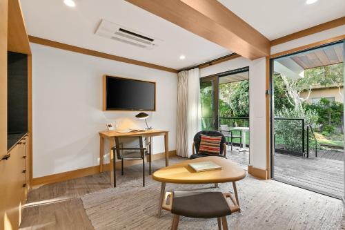 a living room with a table and a tv at SA Carbon Beach Suites in Malibu