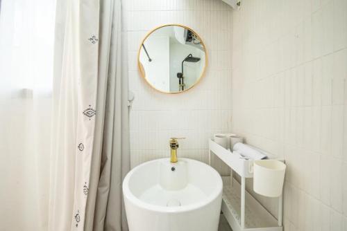 uma casa de banho branca com um lavatório e um espelho em Shanghai Hills & Serendipity Bnb em Xangai
