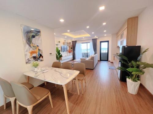 a dining room and living room with a table and chairs at FLC Sea Tower Quy Nhơn__Du Lịch Bình Định in Quy Nhon