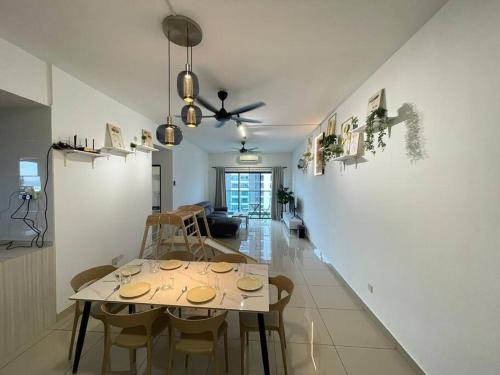 10 Pax-Cozy Family Suite Landmark 2 في كاجانغ: غرفة طعام مع طاولة وبعض الكراسي